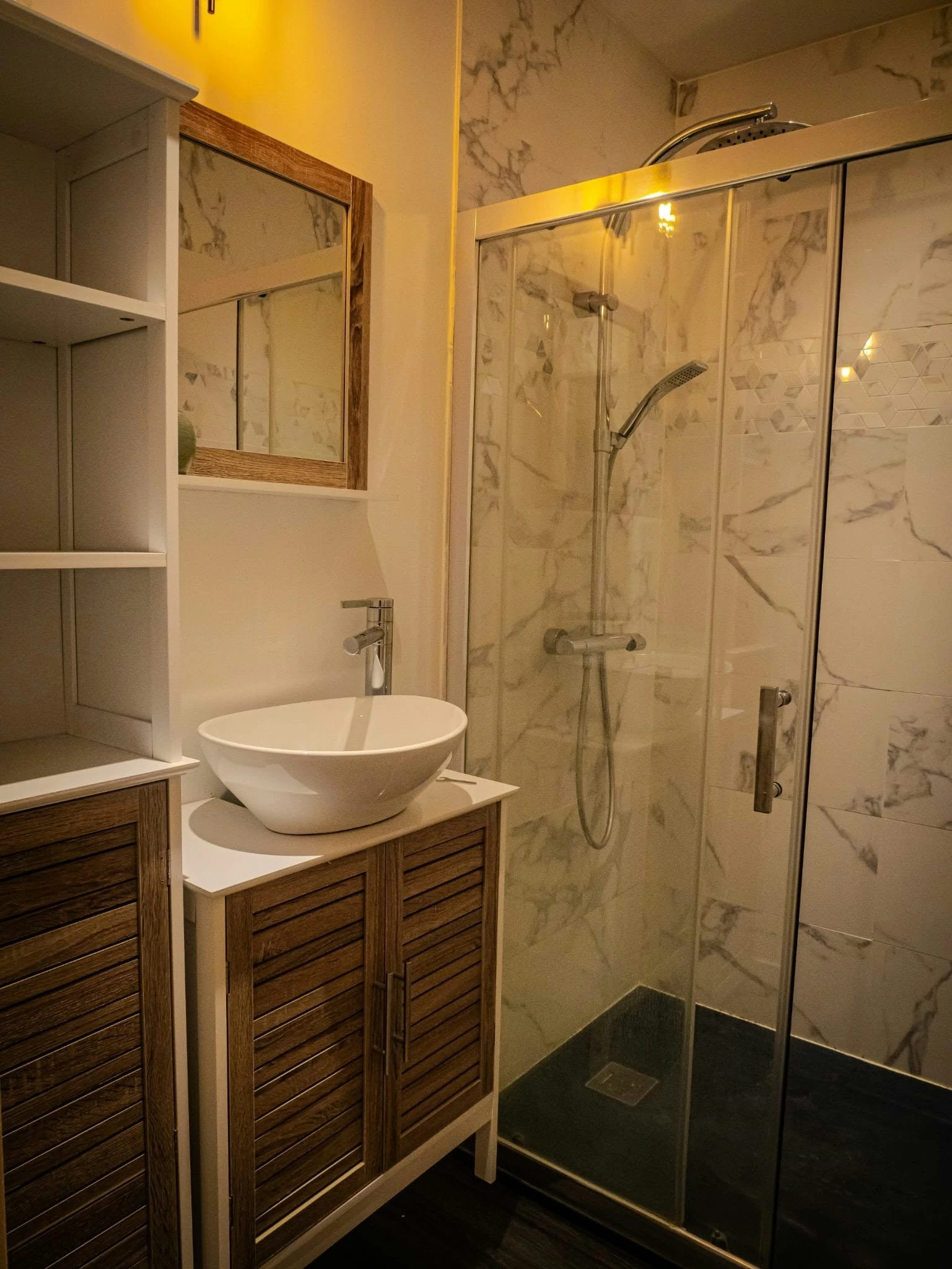 Salle de bains compacte avec douche vitrée et meuble bois